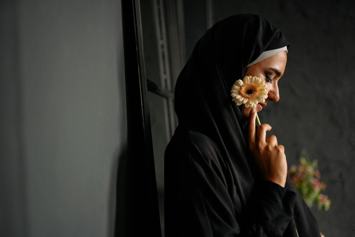 woman in black hijab holding a flower