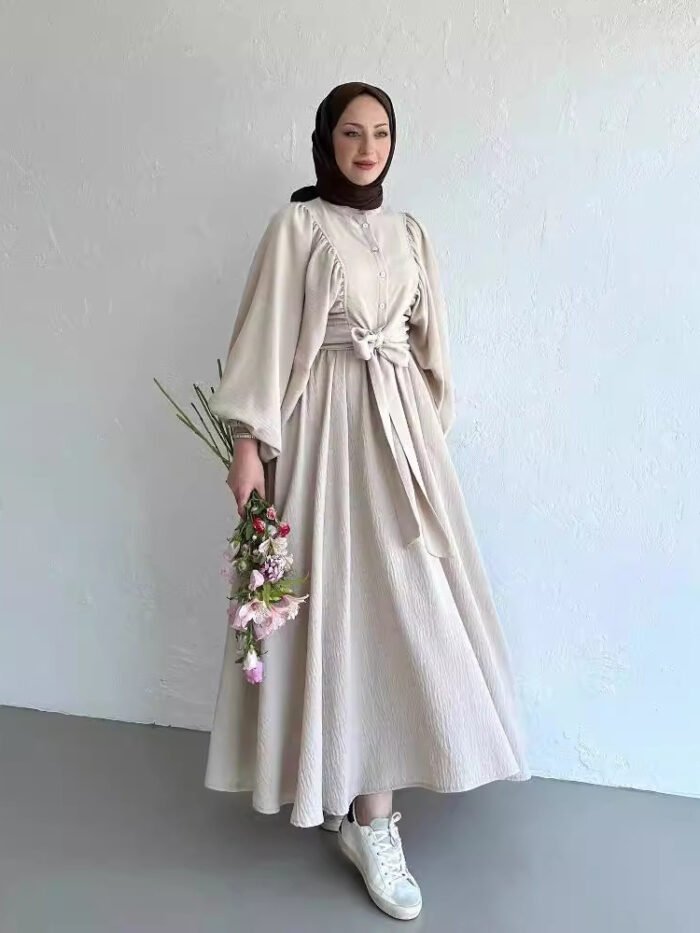 a woman in a dress holding flowers, fashion abaya outfit