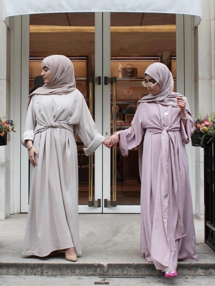 two women wearing dresses standing on a porch, abaya buy