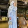 a woman in a blue dress covering her face,abaya fashion show