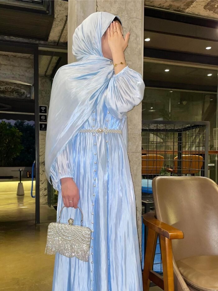 a woman in a blue dress covering her face,abaya fashion show
