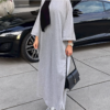 a woman wearing a grey dress and a black purse, dress abaya,