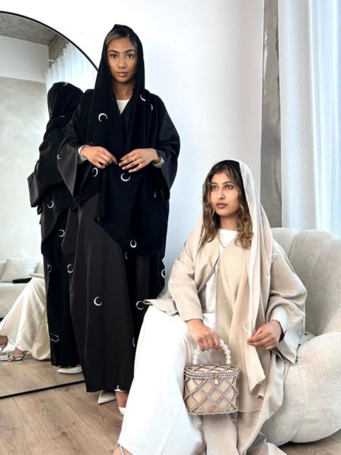 a group of women in black robes, butterfly abaya