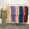 a rack of dresses with a mannequin in front of it, abaya fashion islam