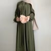 a woman in a green dress holding a pink flower, abaya women
