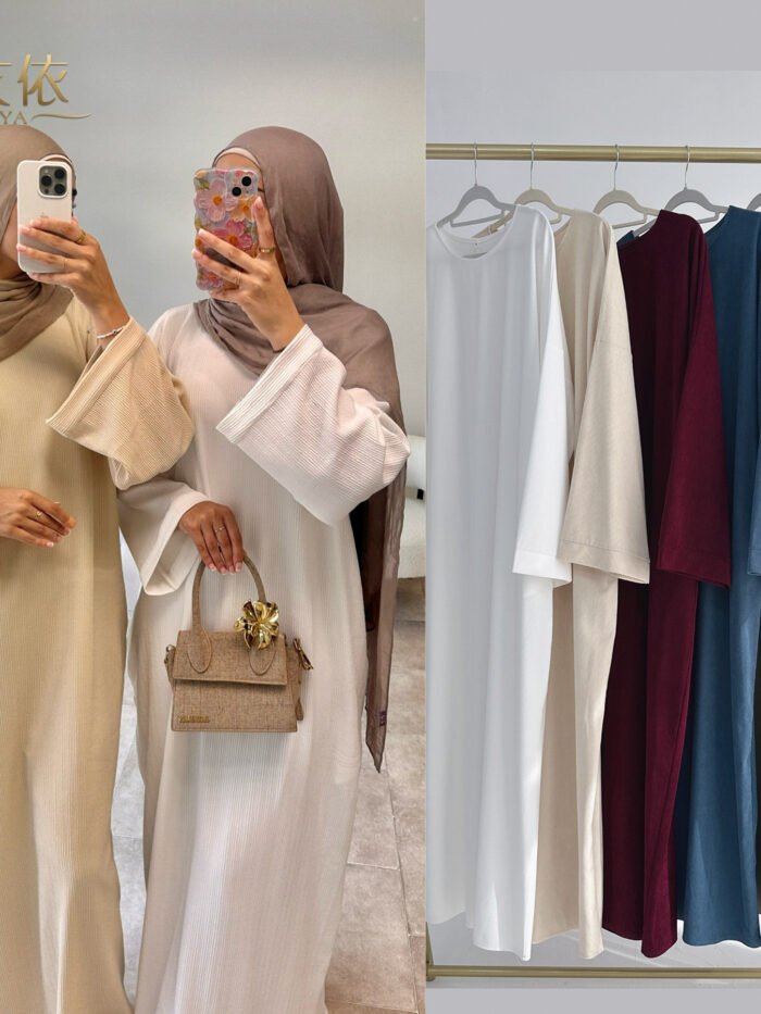 a woman taking a selfie in front of a rack of clothes'abaya fashion new design