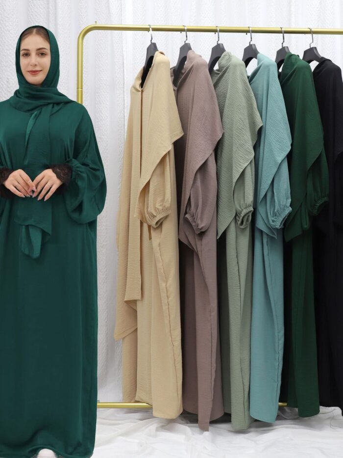 a woman standing in front of a rack of clothes, plus size abayas